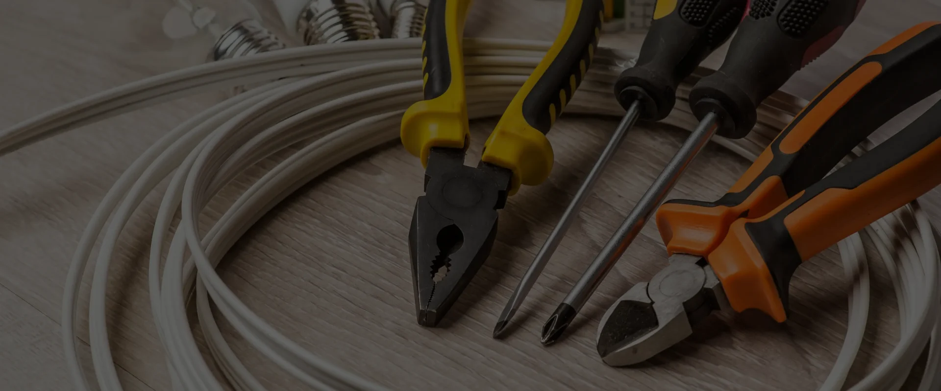 Close-up of pliers and screwdrivers on cable