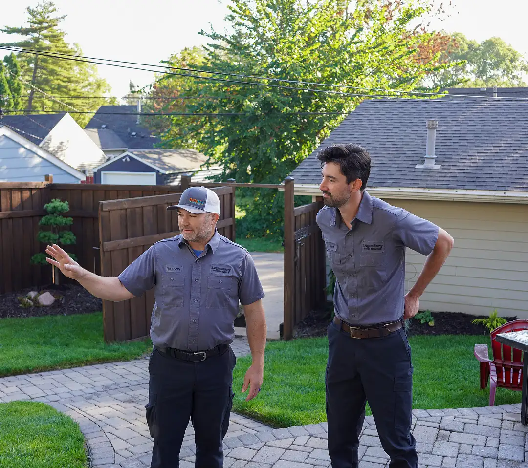Two technicians speaking outside home